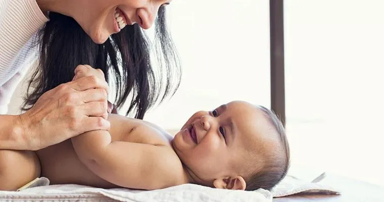 How do I go about changing a diaper when my mom experiences a lot of pain on her broken leg?
